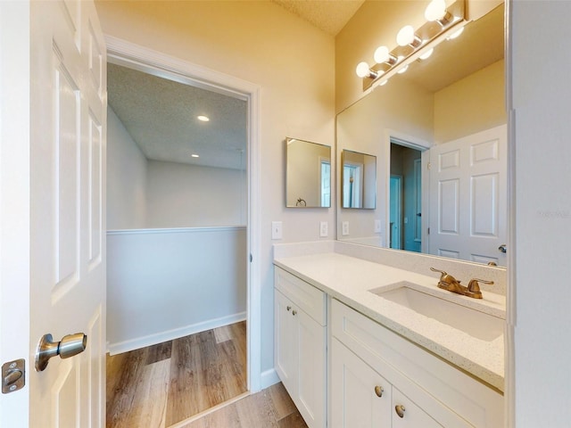 bathroom with hardwood / wood-style floors, a textured ceiling, and vanity