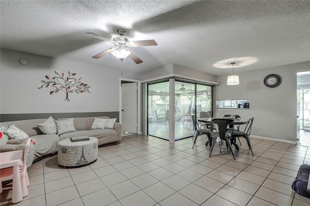 tiled living room with ceiling fan and a textured ceiling