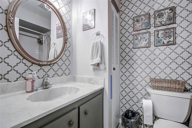 bathroom with curtained shower, toilet, and vanity