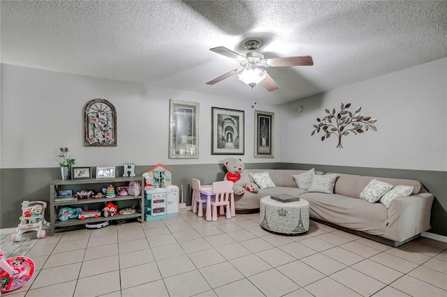 living room featuring a textured ceiling, light tile patterned floors, and ceiling fan