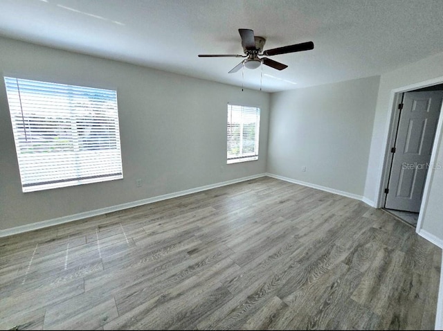 unfurnished room featuring ceiling fan, light wood-type flooring, and a textured ceiling