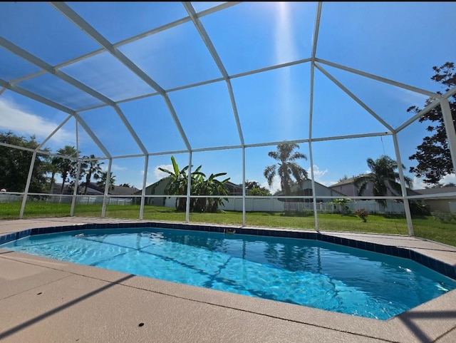 view of swimming pool with a lawn and a lanai