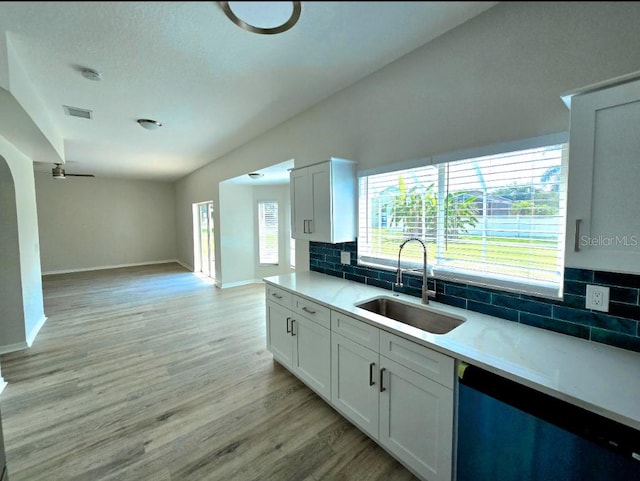 kitchen featuring sink, decorative backsplash, light hardwood / wood-style floors, and white cabinets