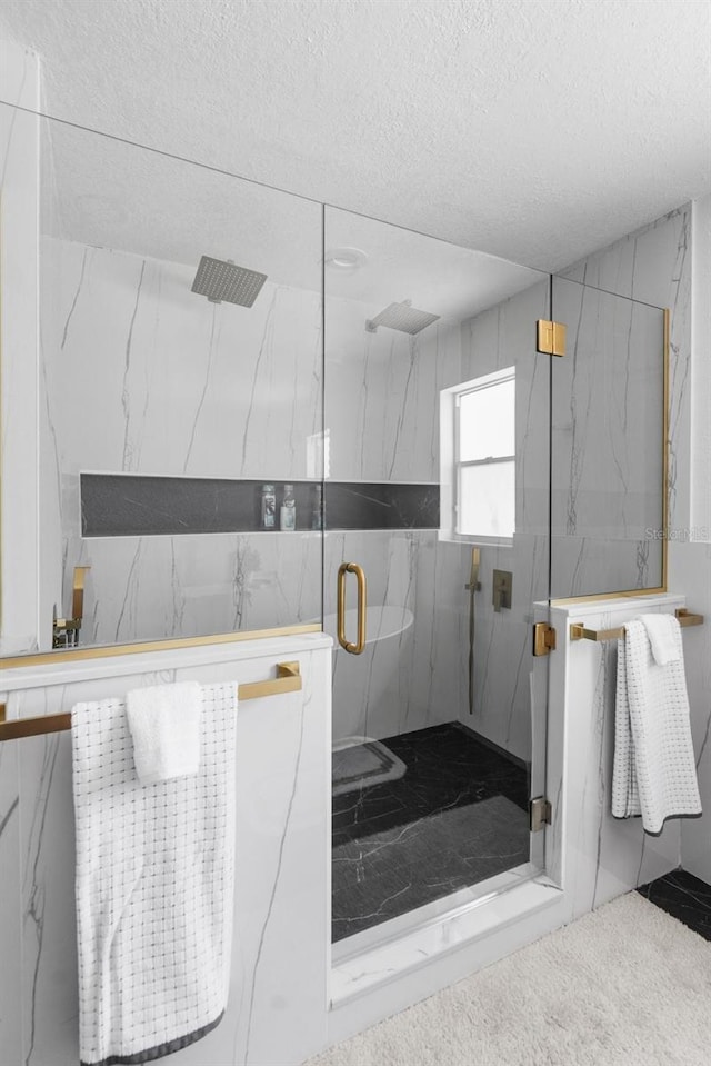 bathroom with a textured ceiling and a marble finish shower