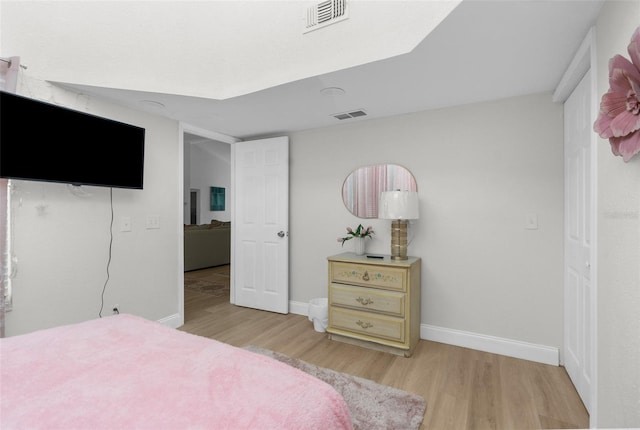 bedroom featuring light wood-type flooring, visible vents, and baseboards