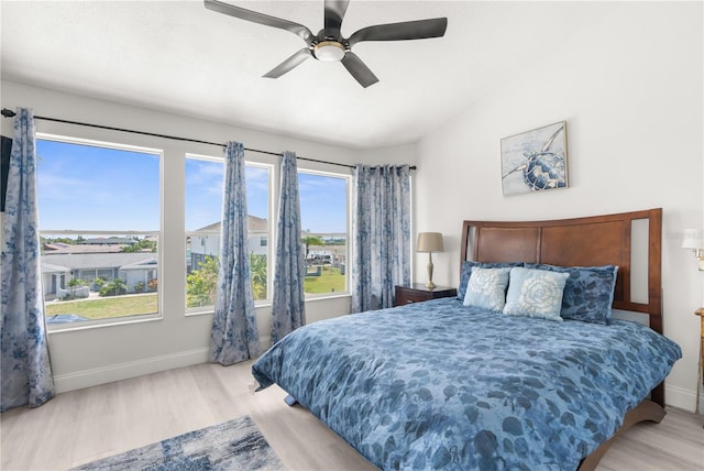 bedroom featuring lofted ceiling, light wood-style floors, and baseboards