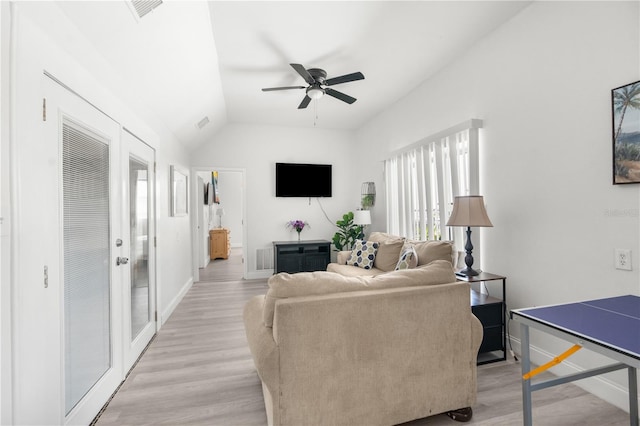 living room featuring ceiling fan, vaulted ceiling, and light hardwood / wood-style flooring