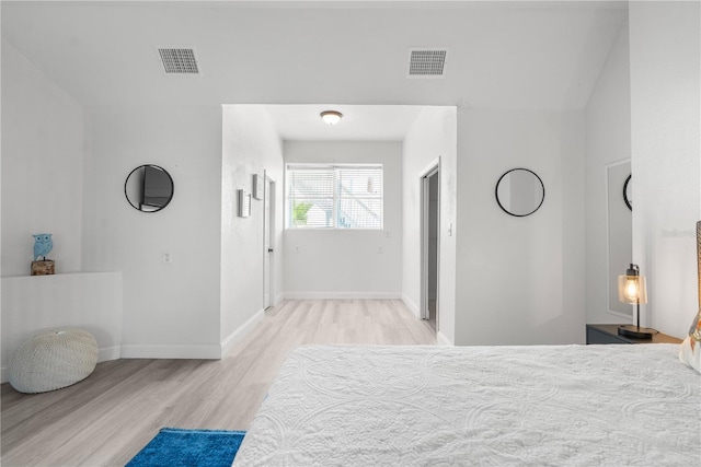 bedroom with light wood-type flooring, visible vents, and baseboards