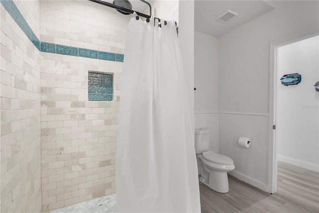 bathroom with hardwood / wood-style flooring, curtained shower, and toilet