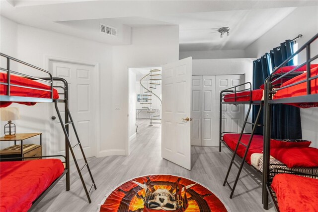 bedroom with baseboards, visible vents, and light wood-style floors