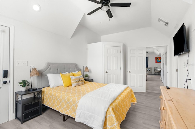 bedroom with lofted ceiling, a ceiling fan, visible vents, and wood finished floors