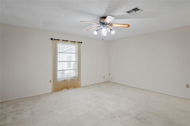 carpeted spare room featuring ceiling fan and a textured ceiling