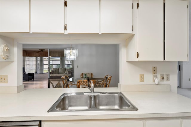 kitchen featuring white cabinets, pendant lighting, and sink