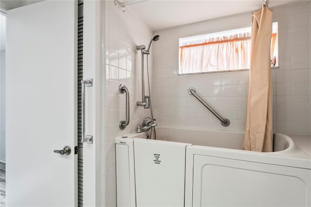 interior space featuring shower / bath combination with curtain and washer / dryer