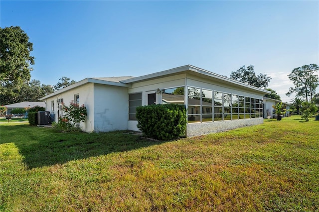 view of side of property featuring cooling unit and a yard