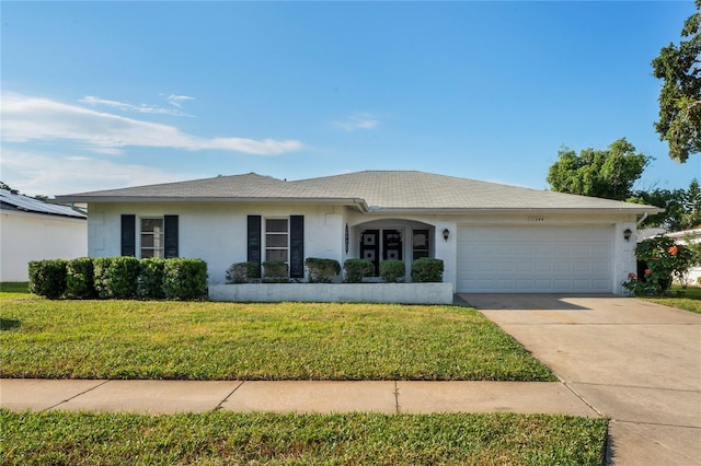 ranch-style home with a garage and a front yard