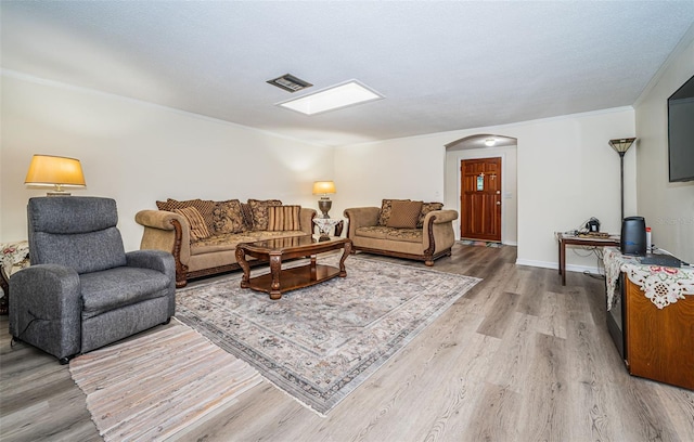 living room with wood-type flooring and crown molding