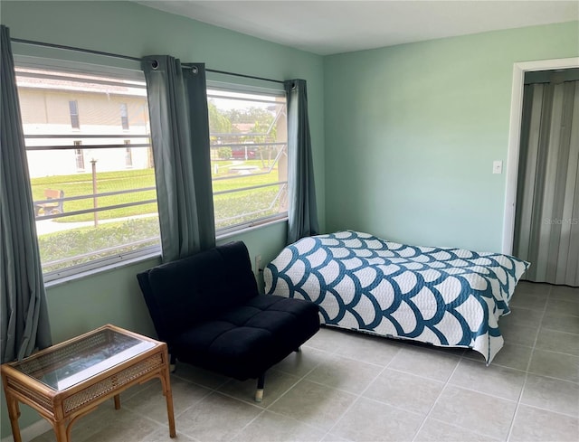 bedroom featuring multiple windows and light tile patterned floors