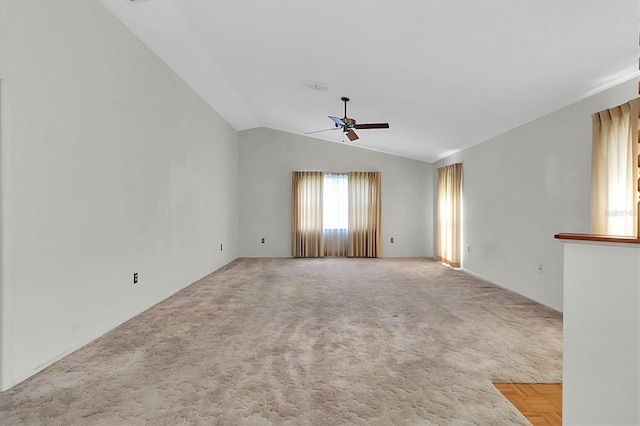 spare room with carpet, vaulted ceiling, visible vents, and ceiling fan