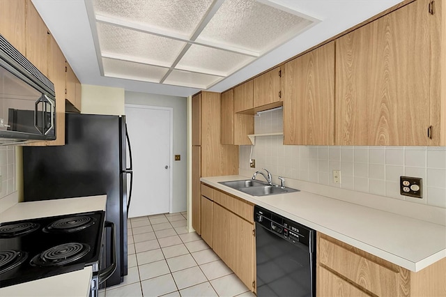 kitchen with light tile patterned floors, light countertops, backsplash, a sink, and black appliances