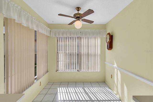 empty room featuring a ceiling fan and tile patterned flooring