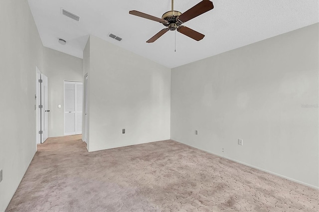 carpeted empty room with a high ceiling and ceiling fan