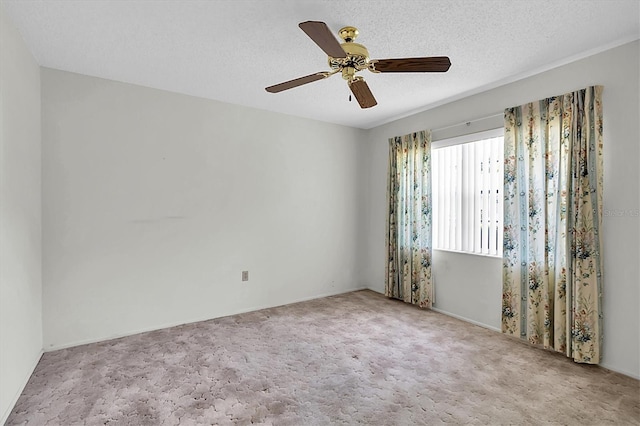 empty room featuring carpet floors, ceiling fan, and a textured ceiling