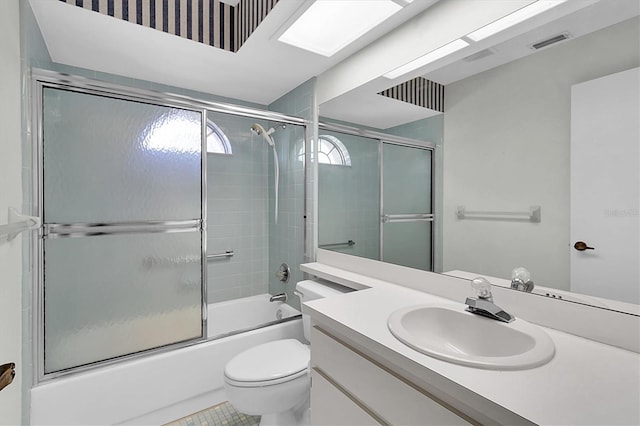 full bath featuring toilet, visible vents, bath / shower combo with glass door, and vanity