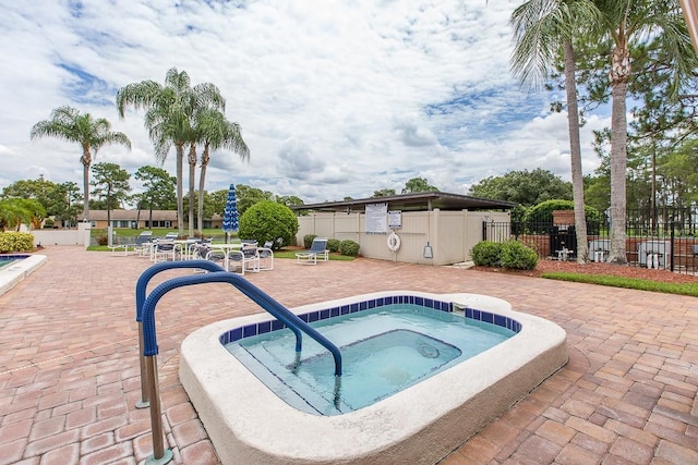 view of swimming pool with a patio area, fence, and a hot tub