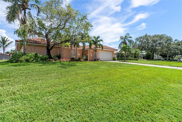 mediterranean / spanish home with a front lawn and a garage