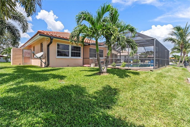 2044 Montana Ave NE, Saint Petersburg, FL 33703 - back of house featuring a tiled roof, a lanai, a lawn, and stucco siding