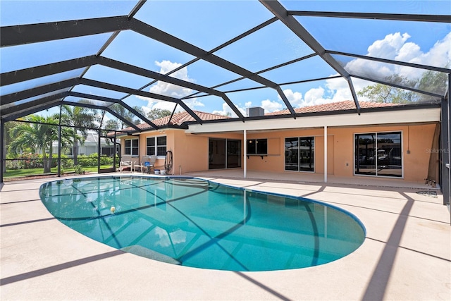 view of swimming pool with glass enclosure and a patio