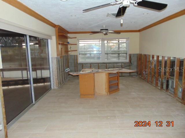 kitchen with a textured ceiling and crown molding