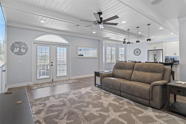 living room featuring ceiling fan, beam ceiling, dark wood-type flooring, and french doors