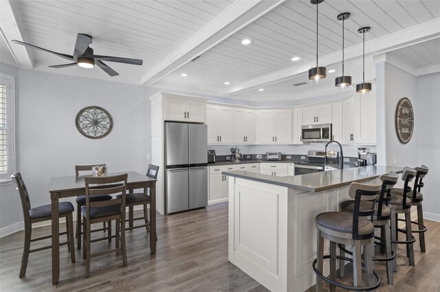 kitchen featuring white cabinets, beamed ceiling, dark hardwood / wood-style floors, and stainless steel appliances