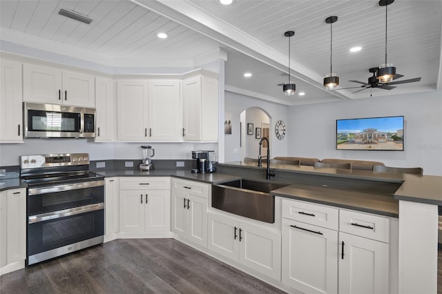 kitchen with appliances with stainless steel finishes, sink, dark wood-type flooring, white cabinets, and ceiling fan