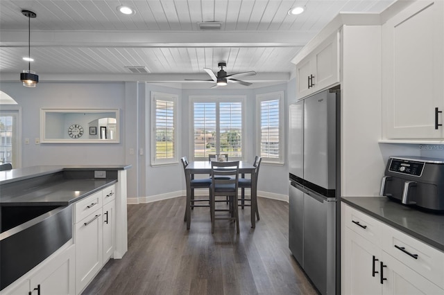 kitchen with beam ceiling, stainless steel refrigerator, white cabinets, dark hardwood / wood-style flooring, and wood ceiling