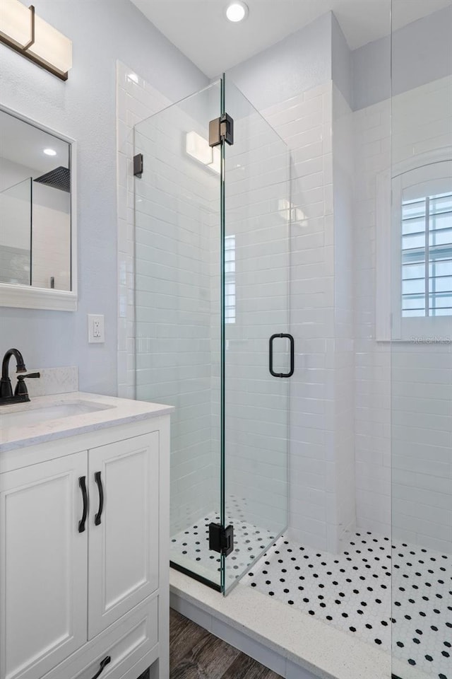 bathroom featuring an enclosed shower, vanity, and hardwood / wood-style floors