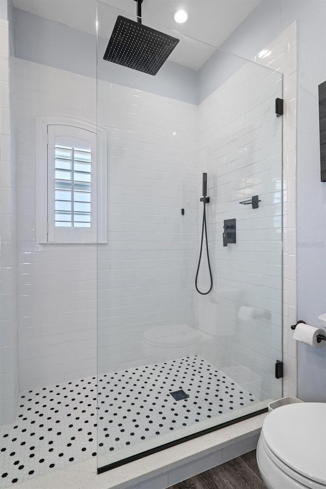 bathroom featuring an enclosed shower, hardwood / wood-style floors, and toilet