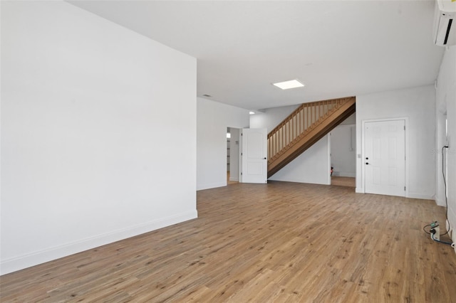 interior space featuring a wall mounted air conditioner and light hardwood / wood-style flooring