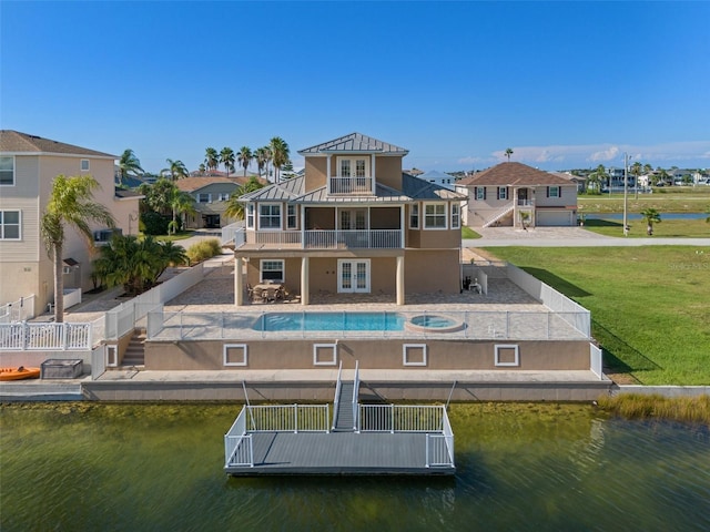 back of property featuring a patio, a yard, a balcony, and a water view