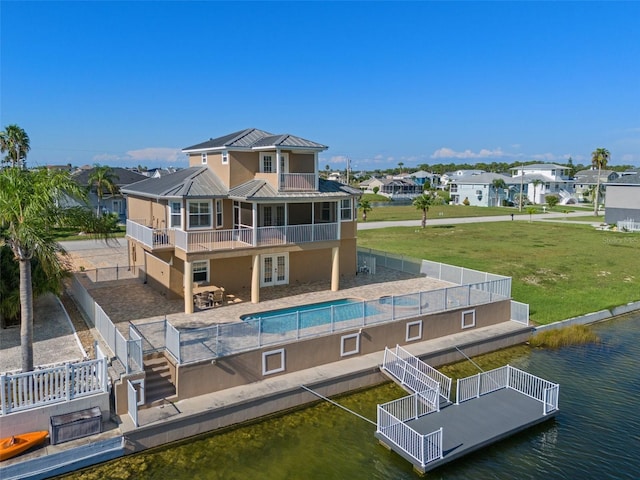 back of property featuring a yard, a patio, and a water view