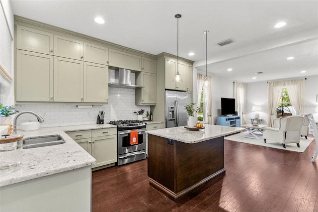 kitchen with dark wood-type flooring, light stone counters, sink, appliances with stainless steel finishes, and decorative light fixtures