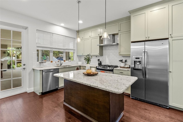 kitchen with stainless steel appliances, light stone counters, decorative light fixtures, a kitchen island, and dark wood-type flooring