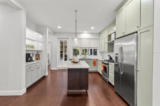 kitchen with stainless steel appliances, light stone counters, a kitchen island, dark wood-type flooring, and pendant lighting