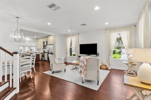 living room featuring a notable chandelier and dark hardwood / wood-style floors