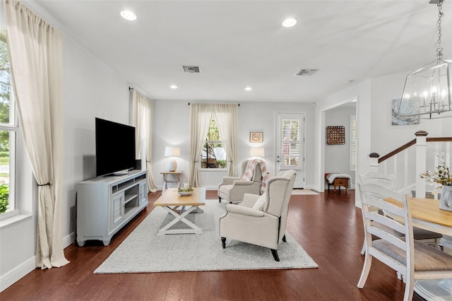 living room featuring dark hardwood / wood-style flooring and an inviting chandelier