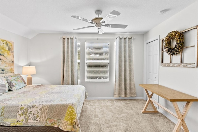 bedroom featuring light carpet, ceiling fan, a textured ceiling, a closet, and vaulted ceiling