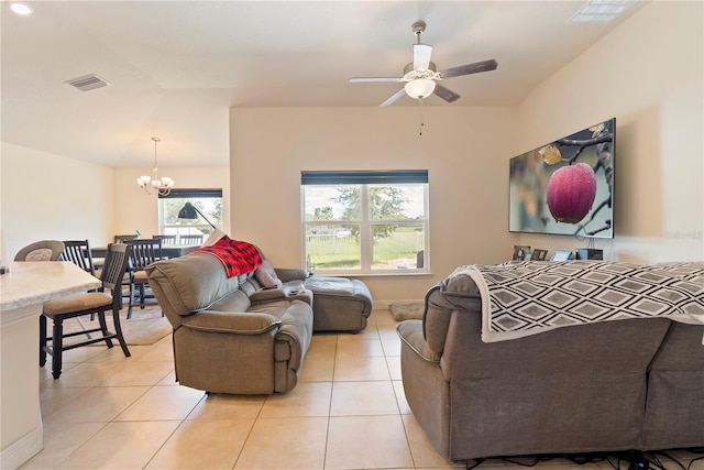 living room featuring ceiling fan with notable chandelier and light tile patterned flooring