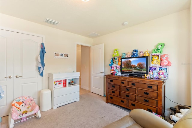 bedroom with light colored carpet and a closet